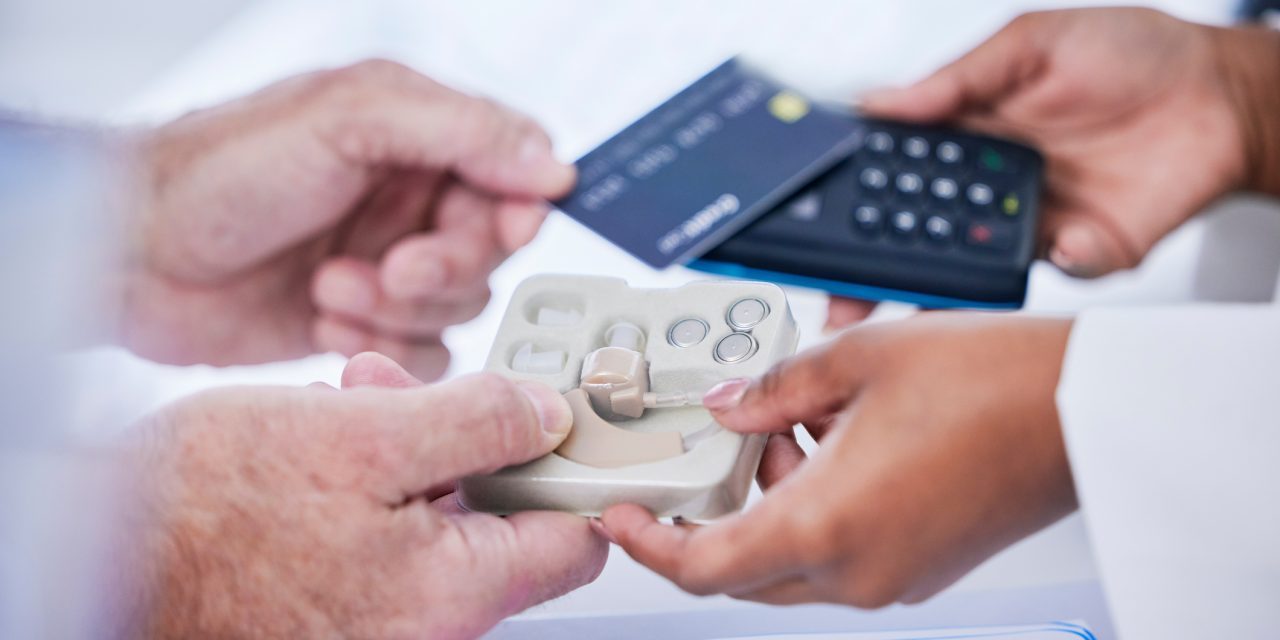 Man purchasing hearing aids with credit card